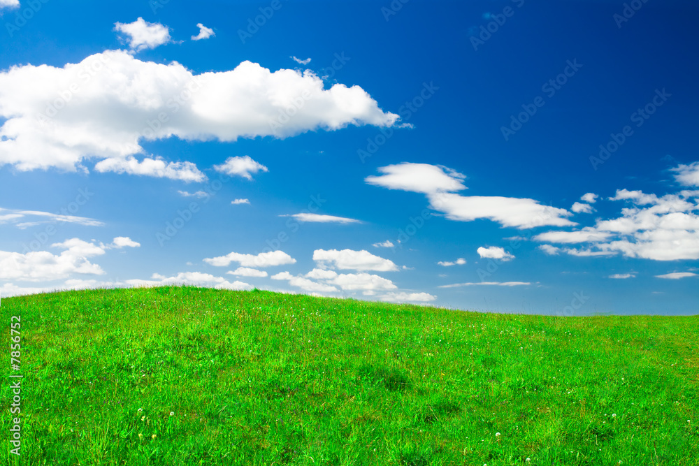Green hill under blue cloudy sky