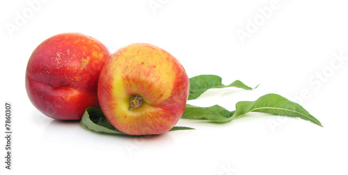 Nectarines with leaves isolated on white background