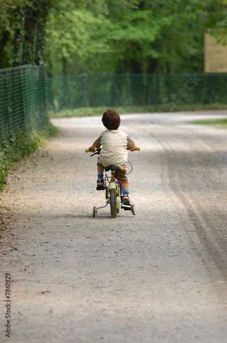 bambino in bicicletta di spalle