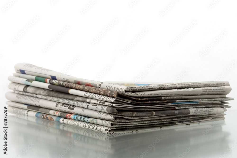 Heap of newspapers on shiny reflecting surface Heap of newspapers on shiny reflecting surface