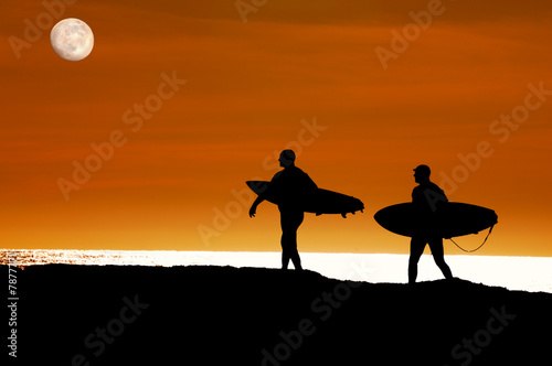 Surfers walking to the ocean for a sunset ride