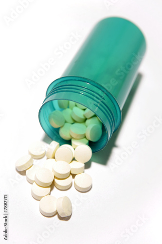 Pills spilling from bottle isolated on white background