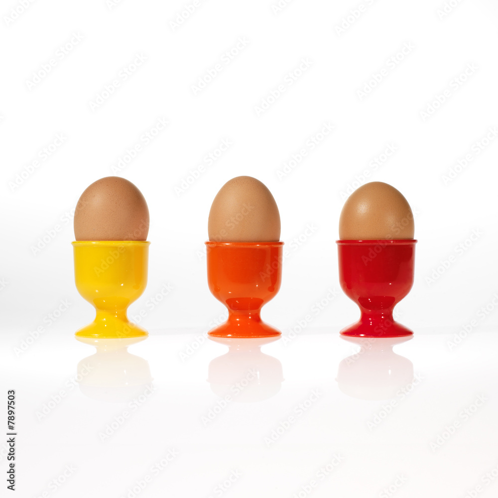 three eggs in colorful egg cups
