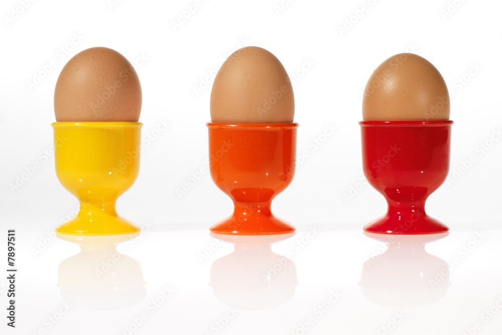 three eggs in colorful egg cups three eggs in colorful egg cups