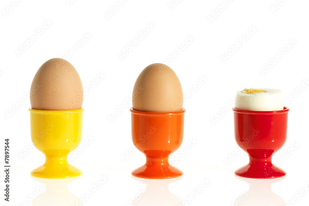 three eggs in colorful egg cups three eggs in colorful egg cups