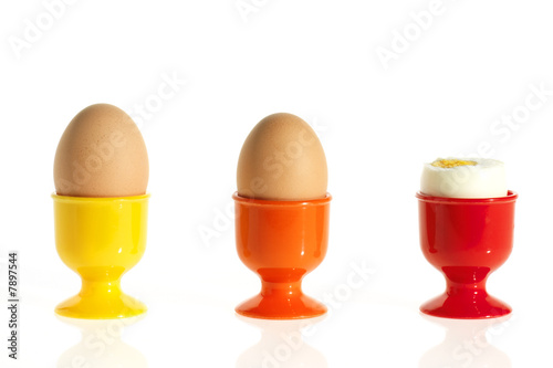 three eggs in colorful egg cups