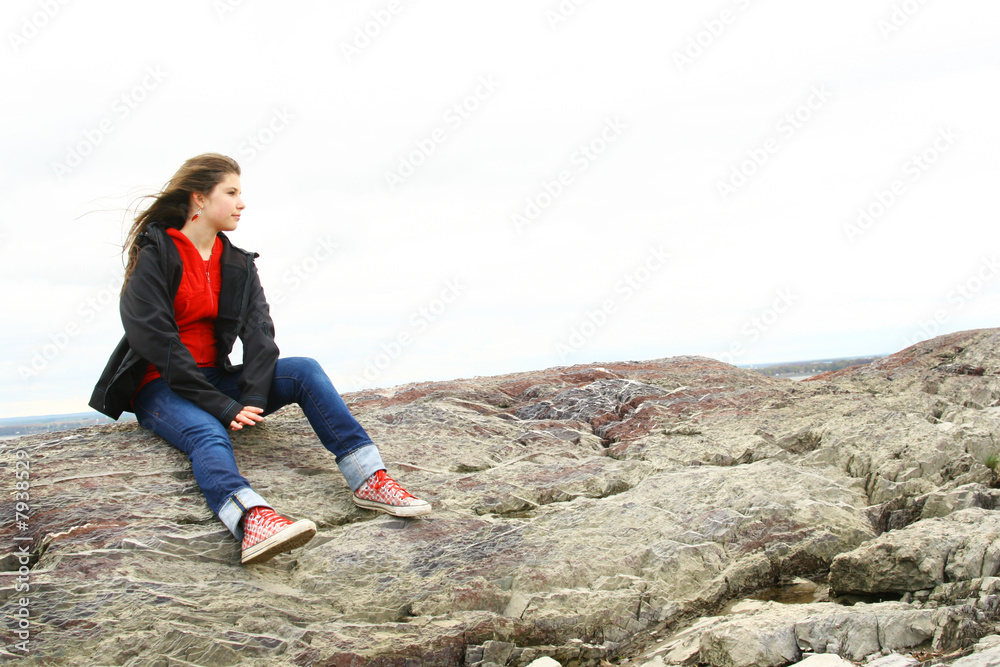 Naklejka premium Teen thinking on stones