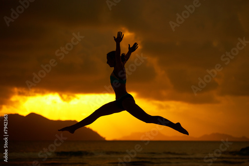 silhouette of jumping woman at sunset