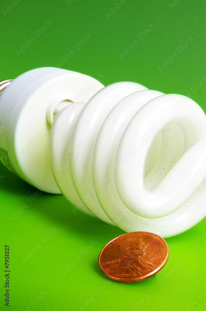 light bulb and penny, closeup on green background light bulb and penny, closeup on green background