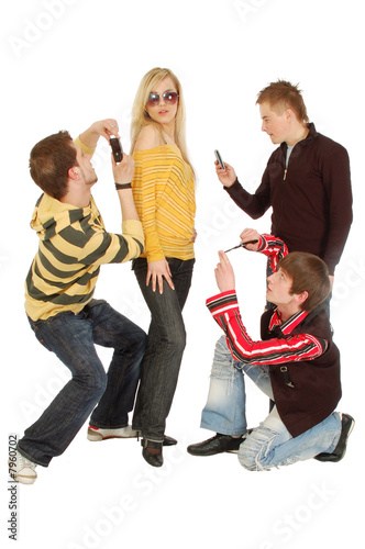 Three guys make photo of a girl by a mobile
