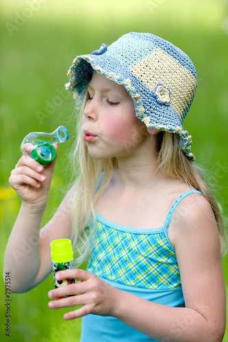 Young girl outside blowing bubbles photo