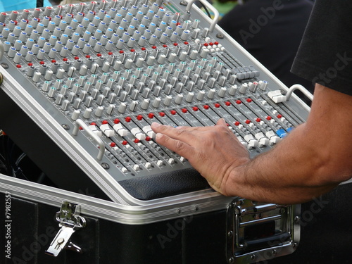 Main de technicien réglant une console.