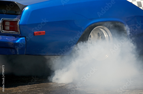 Smoke from the tires of a blue racer 1