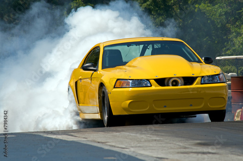 Smoke from the tires of a yellow racer