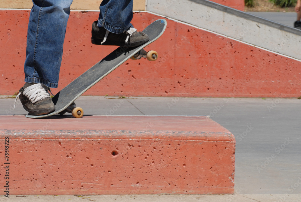 skateboard feet doing tail grind off ramp at skatepark skateboard feet doing tail grind off ramp at skatepark