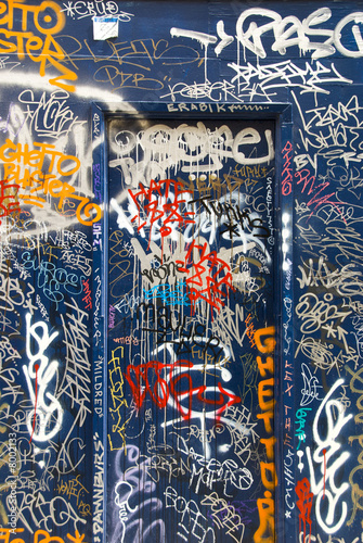 Blue doorway with graffiti tags
