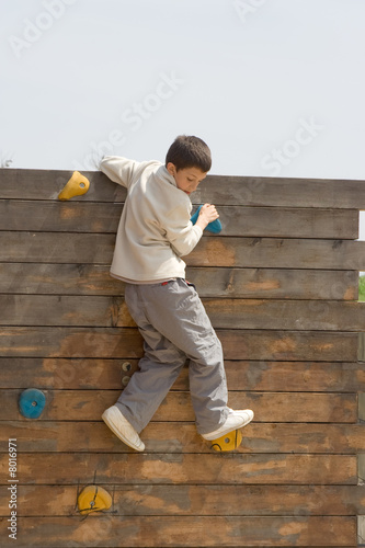 niño escalando una pared de madera