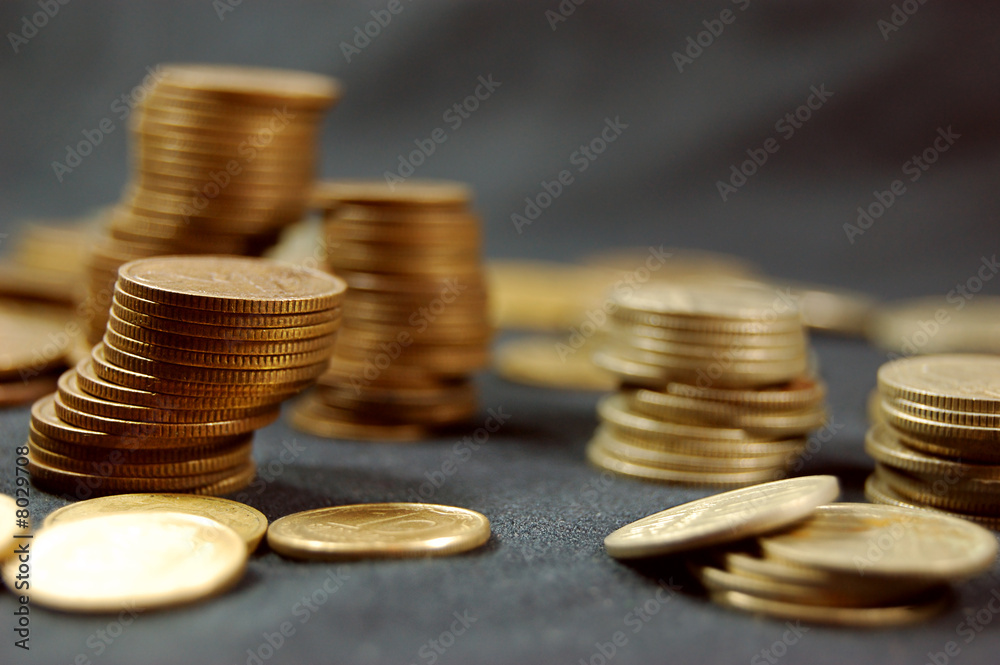 A pile of golden coins on dark background A pile of golden coins on dark background