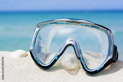 Mask on white sand beach