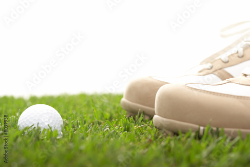 high key shot of golfball with golfshoes