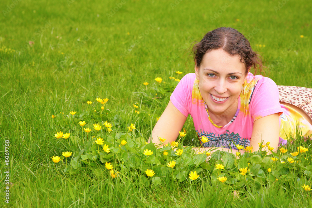 young woman lies on grass