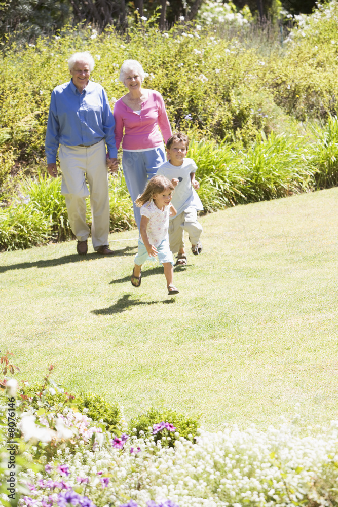 Fototapeta premium Grandparents walking with grandchildren
