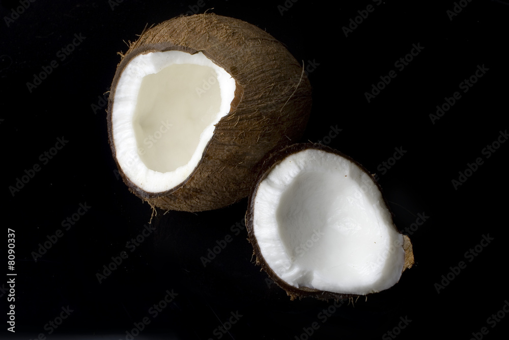 a coconut cracked in two on a black background a coconut cracked in two on a black background