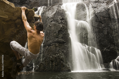 Rock climber at waterfall