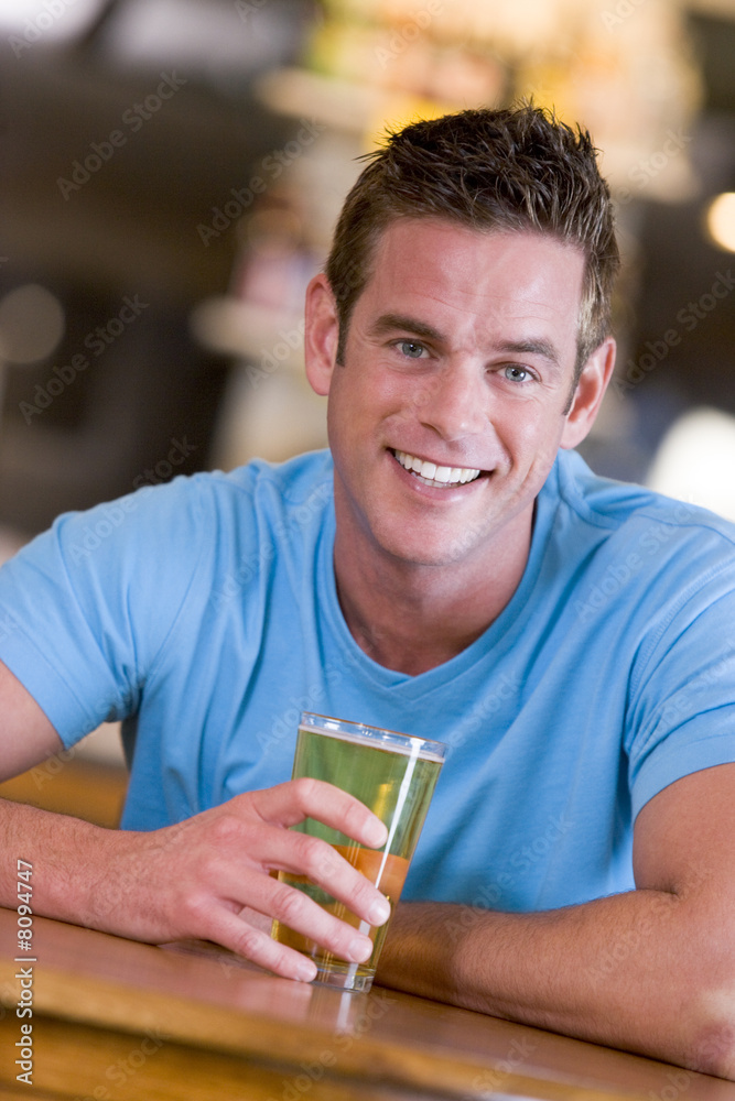 Young man enjoying a beer at a bar Young man enjoying a beer at a bar