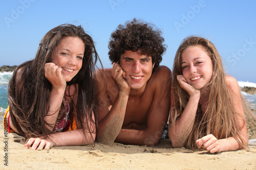 three happy teenagers on the beach