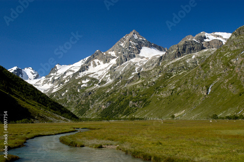 Caucasian alpine pastures, crowned with majestic pyramidic peak