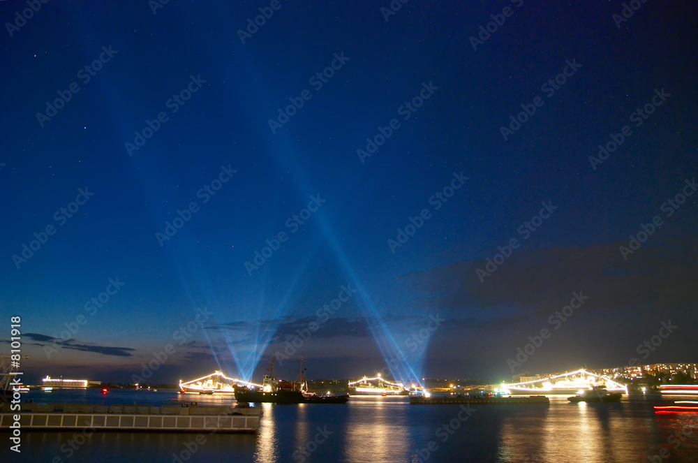 Searchlights in the sky above the bay.