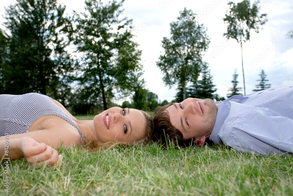 Young happy couple laying on grass Young happy couple laying on grass