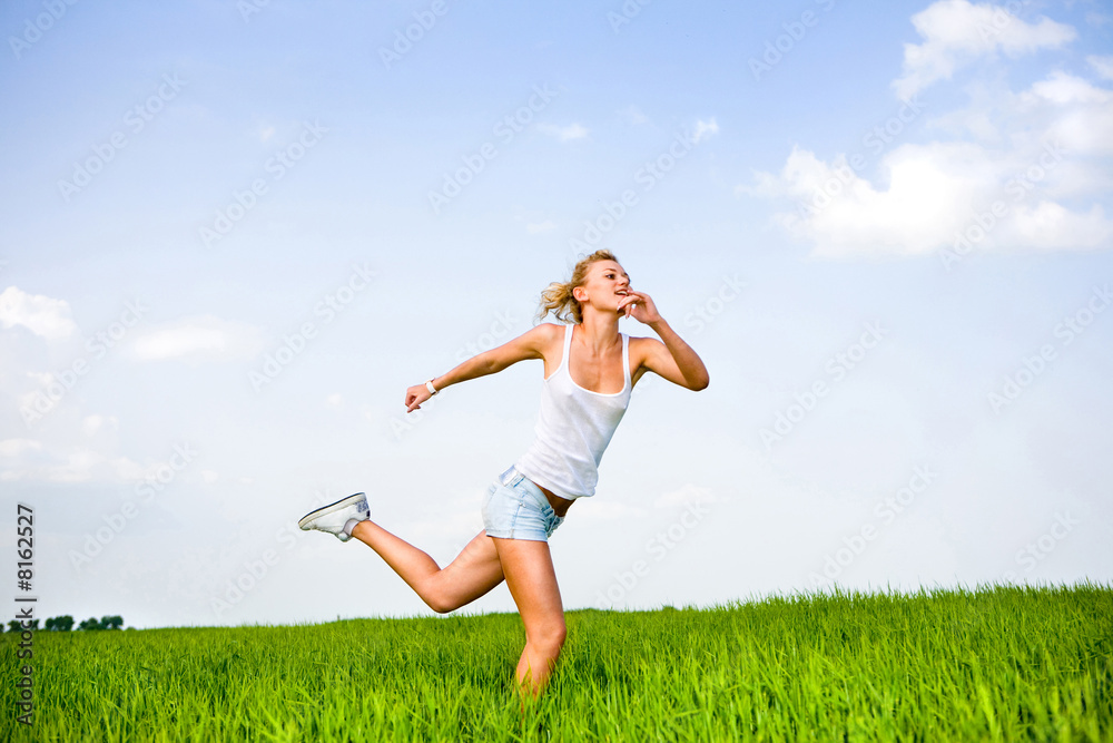 Happy young woman is running in a field Happy young woman is running in a field