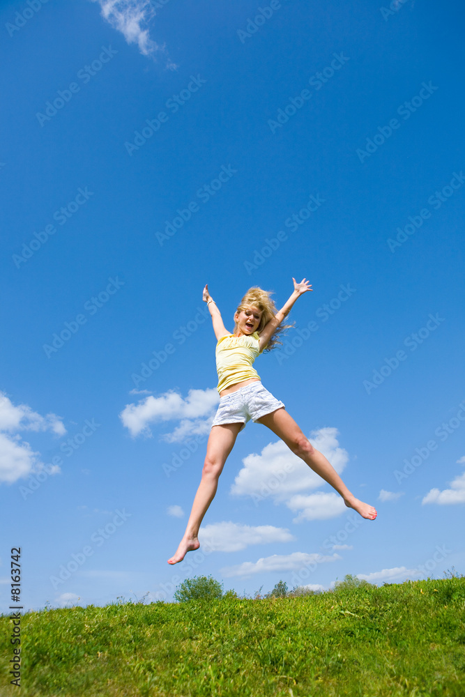 Happy young woman is jumping in a field Happy young woman is jumping in a field