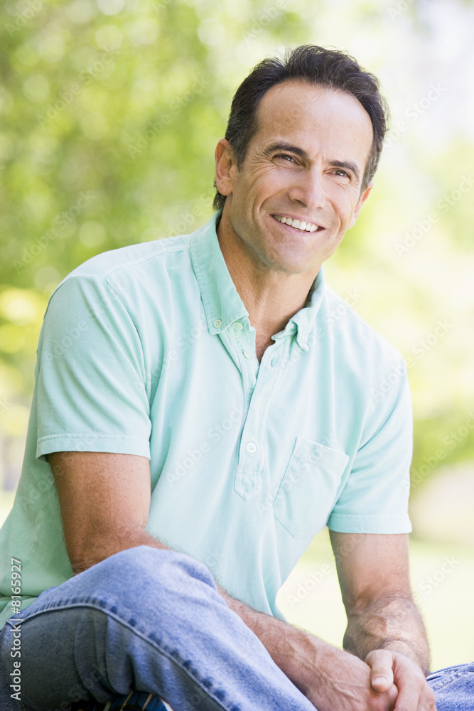 Obraz premium Man sitting outdoors smiling