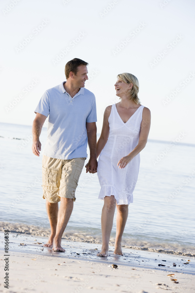 Couple at the beach holding hands and smiling Couple at the beach holding hands and smiling