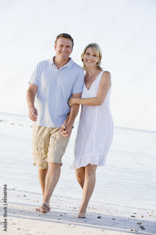 Couple at the beach holding hands and smiling Couple at the beach holding hands and smiling