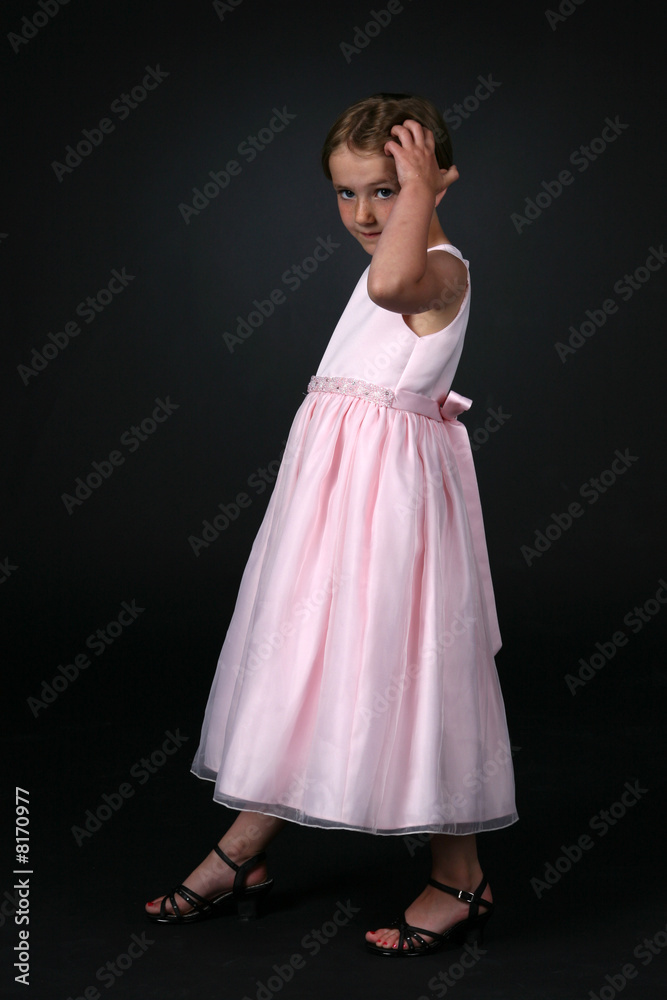 Naklejka premium pretty girl in pink dress, touching her hair