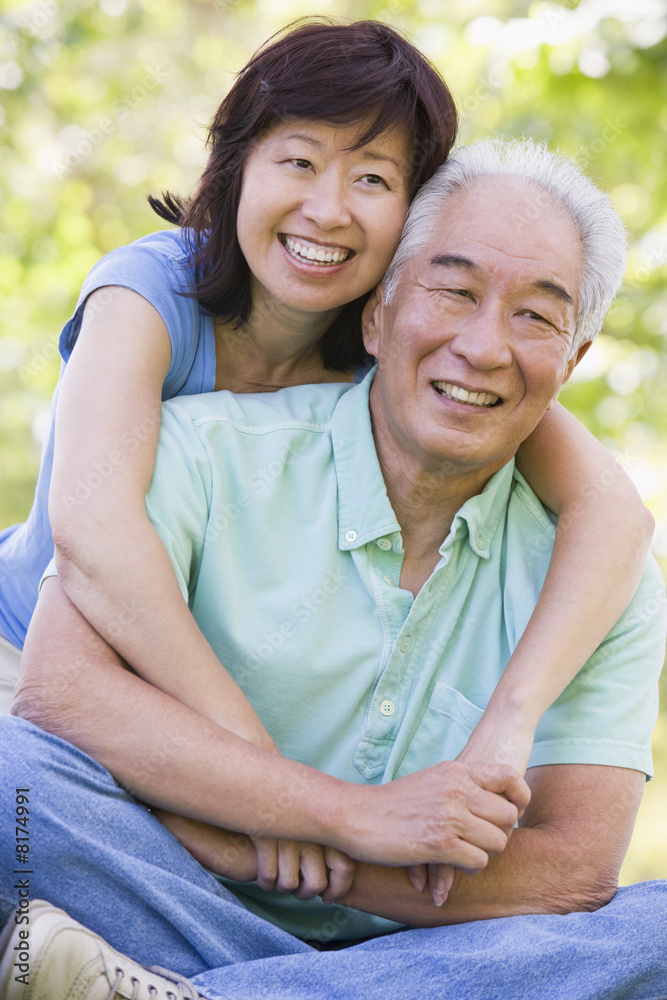 Couple relaxing outdoors in park smiling