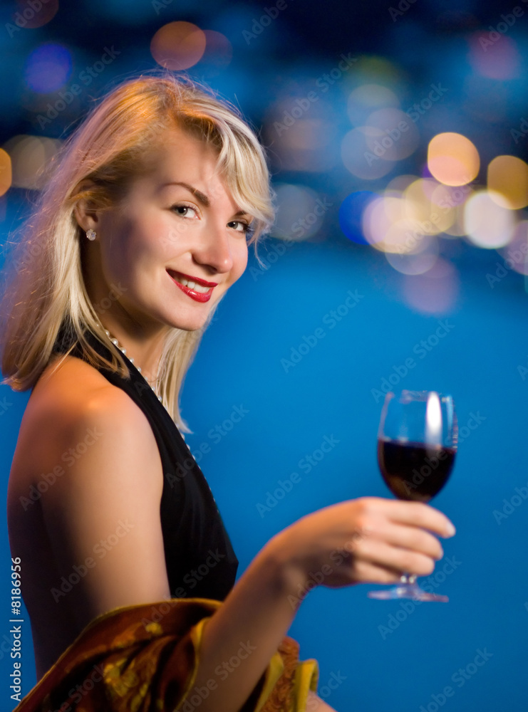 Beautiful young lady drinks wine, abstract blurred background be