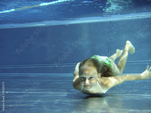 Kleines Mädchen taucht im blauen Pool