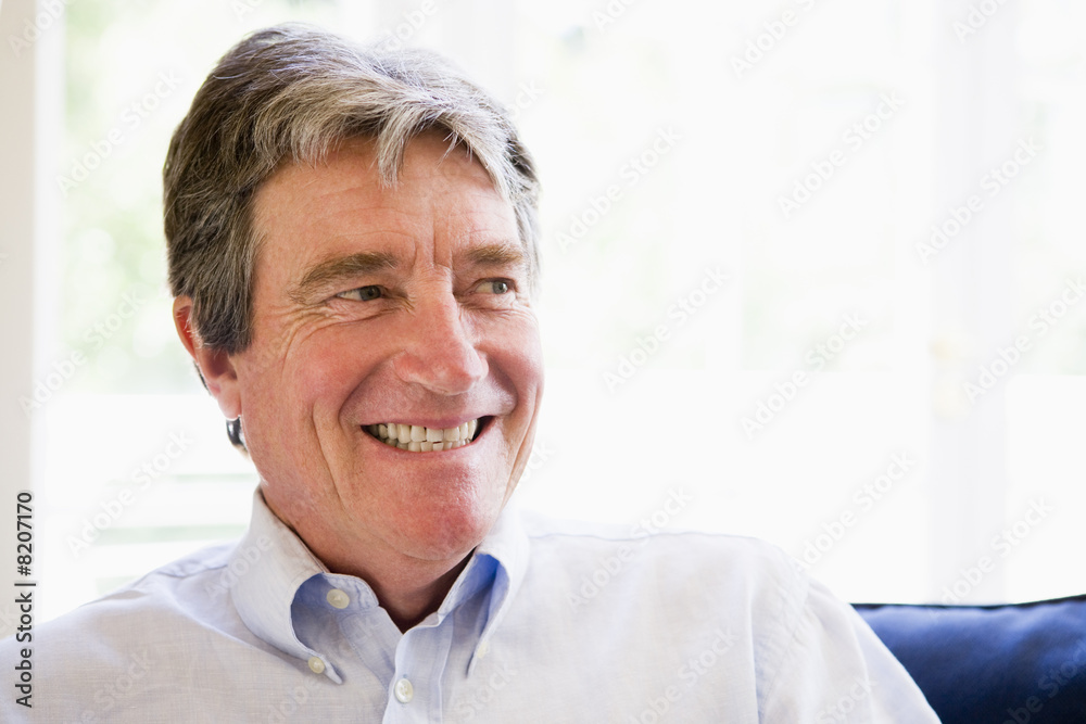Man sitting in living room smiling Man sitting in living room smiling