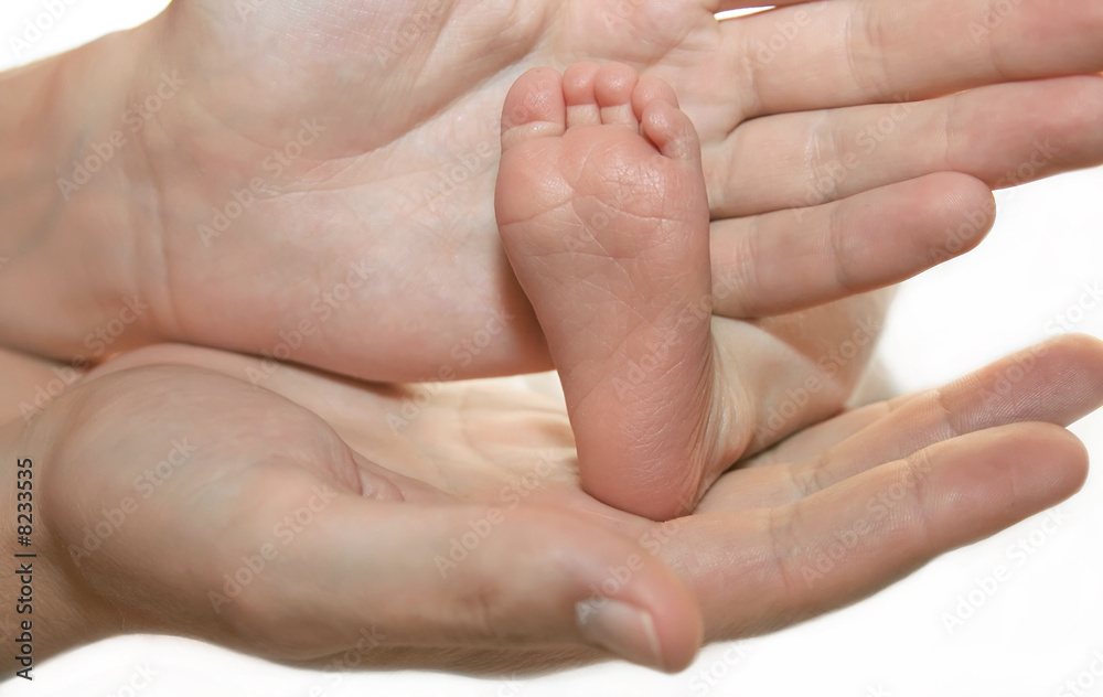 Leg of the newborn child in caring hands Leg of the newborn child in caring hands