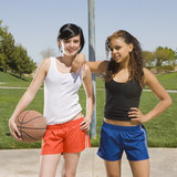 Two teens play at basketball court