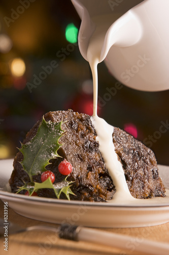 Portion of Christmas Pudding with Pouring Cream photo