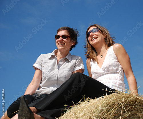 Foto femmes qui sourient assises sur la paille