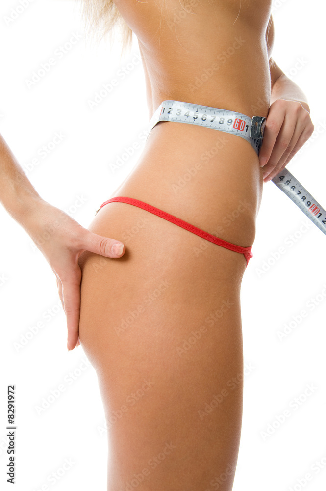 Sexy woman measuring her waist with a measuring tape