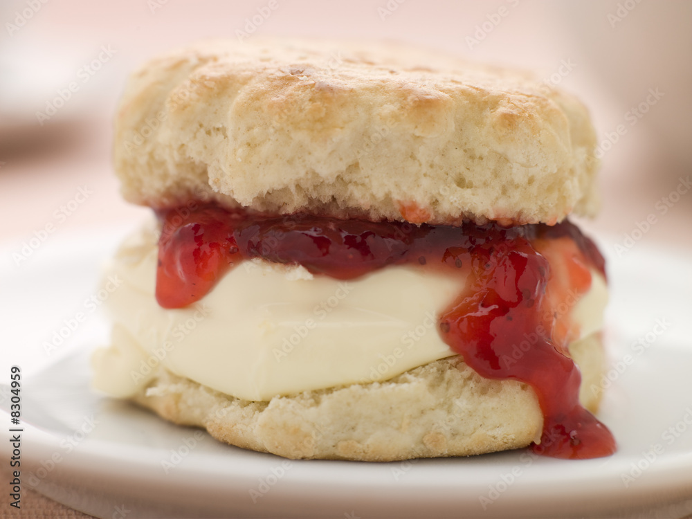 Scone Filled with Strawberry Jam and Clotted Cream on a plate Scone Filled with Strawberry Jam and Clotted Cream on a plate
