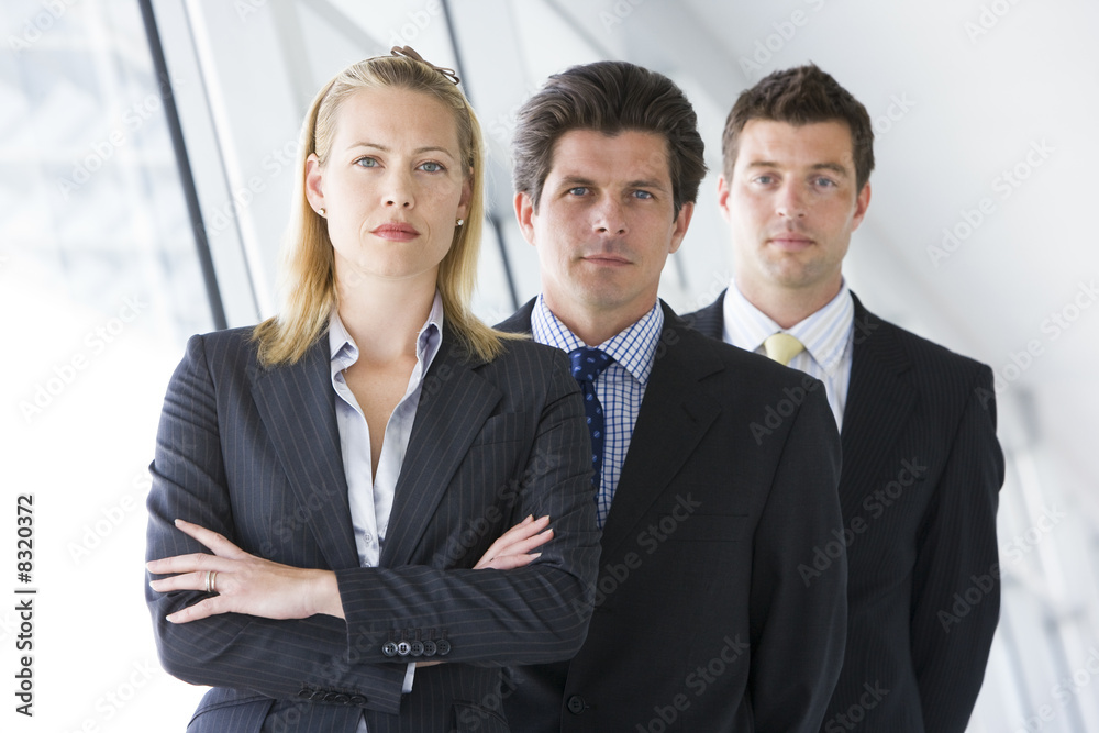 Three businesspeople standing in corridor